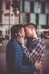 passionate gay couple kissing and hugging each other in the streets