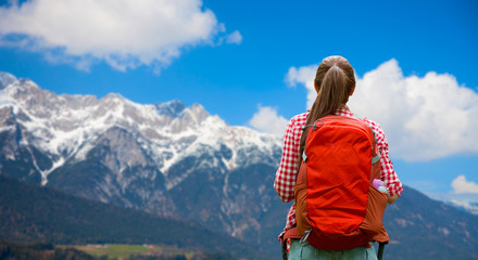 Naklejka na ściany i meble travel, tourism and hike concept - young woman with backpack over alps mountains background