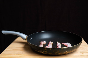 slices of fresh fried bacon in a pan for breakfast
