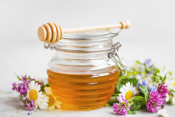 Obraz na płótnie Canvas Raw organic honey jar with flowers