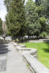 stone path with a beautiful stone fountain in a green park in a city
