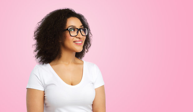 vision, body positive and people concept - happy african american woman in white t-shirt and glasses over pink background