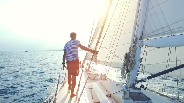 Off shore sailing. Man enjoys beautiful weather conditions on his luxury boat. 4k Video.