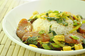 spicy stir fried Chinese pork sausage with basil leaf and rice on plate