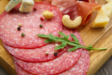 Restaurant meals, gourmet snack, food photo, menu concept. Salami slices on board, close up