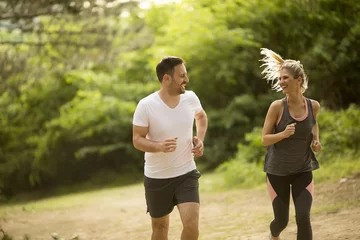 Tuinposter Couple jogging outdoors in nature © BGStock72