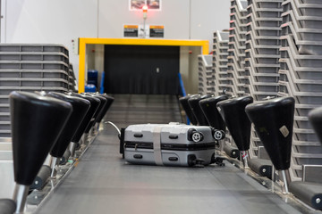 Suitcase on luggage conveyor belt at baggage  handling belt conveyor system at check in desk in...