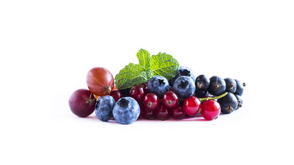 Fruits and berries isolated on white background. Ripe currants, blueberries and gooseberries with a leaf of mint. Sweet and juicy fruits with copy space for text. 