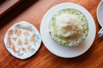 Top view of Japanses melon Kakigōri (shaved ice dessert) served in half of melon and sliced Pama Ham.