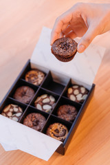 Hand pick Brownie cup cake that topping with variious incredients such as almond, caramel and chocolate chips.