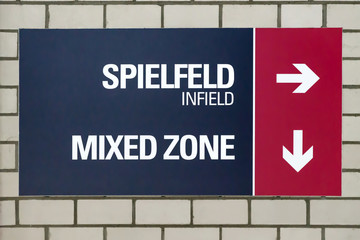 Stadium sign with directional indication for the infield and the Mixed Zone in german and english