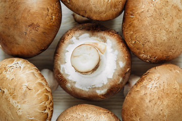 Brown champignon mushrooms lying on a wooden table