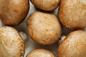 Brown champignon mushrooms lying on a wooden table