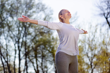 Being outdoors. Happy peaceful woman breathing fresh air while enjoying being outdoors
