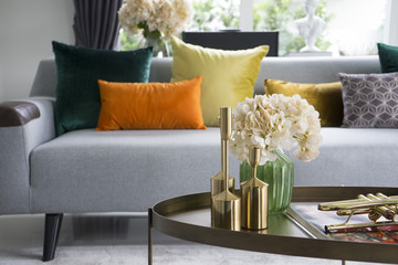 colorful and stylish living room with flower vase and gold trumpet on table.