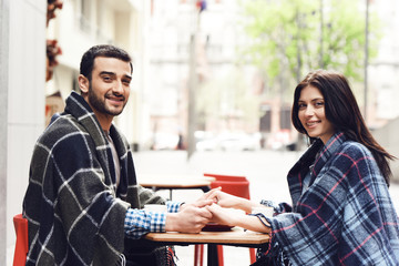 Loving couple in rugs sits at table.
