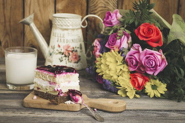 Fototapeta na wymiar cherry jelly cake and beautiful bouquet of flowers on an old wooden background