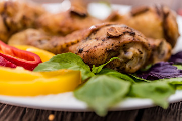 Roasted chicken quarter legs on rustic background