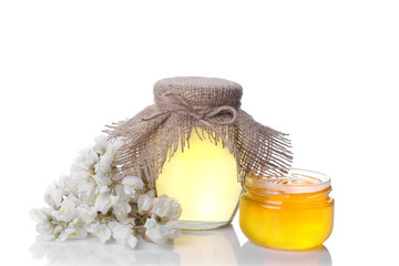Different honey in a glass jar with a sprig of acacia. isolated