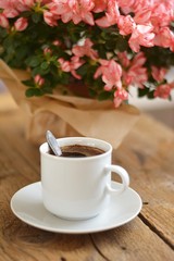 coffee in a white cup with azalea flower