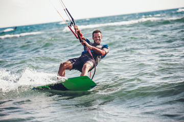 Kitesurfing Kiteboarding action photos man among waves quickly goes