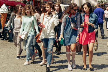 many young happy women walking talking  on background of old european city street, stylish hipster girls having fun, moments of happiness, friendship concept