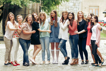 Group of happy stylish women having fun on background of old european city street, travel or celebrating friendship concept, moments of happiness