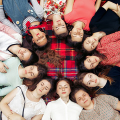 happy group of women faces in circle posing and smiling on picnic top view, lying on blanket, calm and joyful moments celebration in summer park