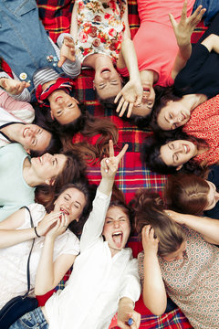 happy group of women faces in circle laughing and having fun on picnic top view, lying on blanket, joyful moments celebration in summer park