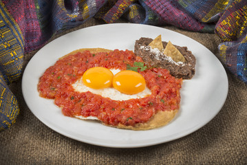 Classic Mexican breakfast surrounded by a traditional zarape