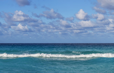 Fototapeta na wymiar line of the ocean, small waves, horizon, endless distance, against the sky covered with clouds, Cuba