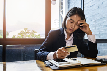 Stressful asian businesswoman with huge amount of credit card debt