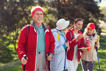 Amazing nature. Alert old man looking around and other hikers talking in the background