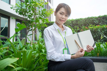 Pretty Asian woman show and present a content of notebook. concept business sale image.