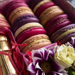 bright composition of macaroni, flowers and a bottle of wine