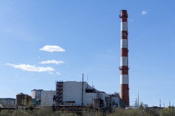 Fototapeta na wymiar shabby building of the shop and the chimney of the thermal power station when also designed to produce heat energy for district heating