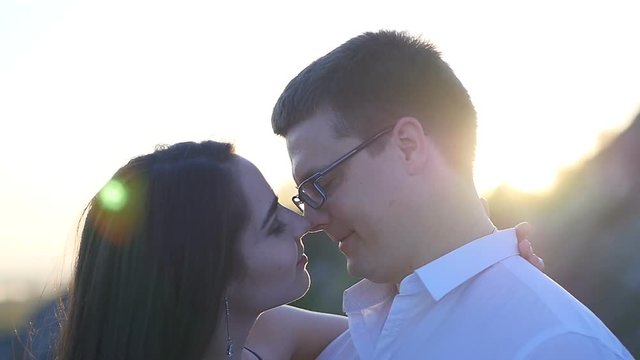 slow motion of young couple kissing erotically with tongue in the flares of sunset light in the city. 1920x1080