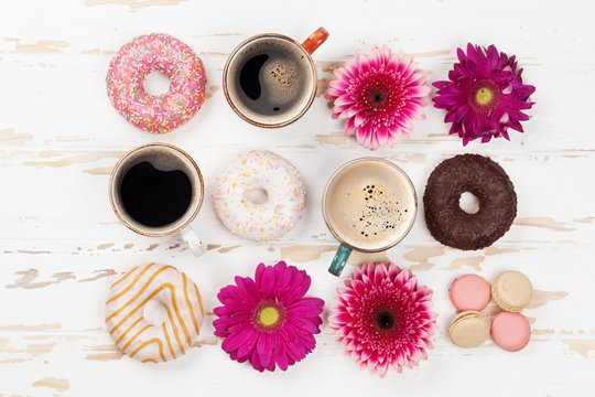 Coffee cups, donuts and gerbera flowers