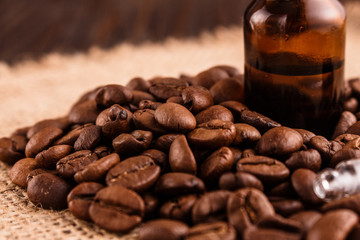 essential oil of coffee beans on a wooden background