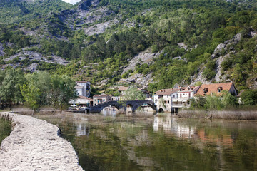 Fototapeta premium asphalt road near the river, green mountains, stone old houses Montenegro