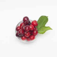 Cherries. Cherry. Cherries in color bowl and kitchen napkin. Red cherry. Fresh cherries. Cherry on white background. Square.