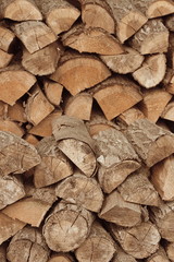 Background of dry chopped firewood logs in a pile.