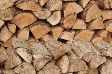 Background of dry chopped firewood logs in a pile.