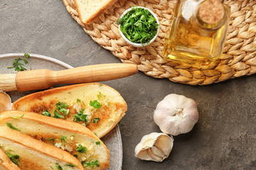 Plate with delicious homemade garlic bread on table