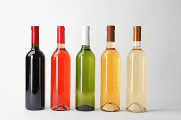 Bottles of expensive wines on light background