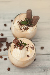 Iced Mocha Frappe Coffee with Whip Cream, Summer Drinking times. Coffee Beans. rustic textured Wooden Background. Mint Leaves