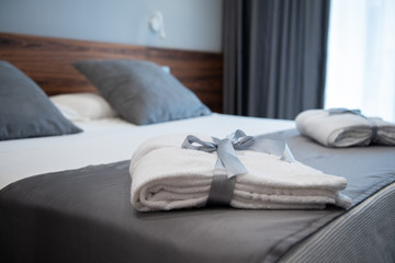 Bathrobe on bed in hotel room - obrazy, fototapety, plakaty