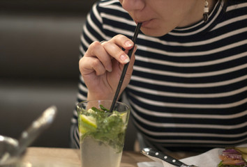 Burger in beautiful female hands. Close-up. Background of no sharpness

