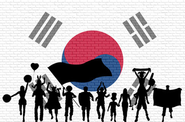 Obraz premium Korean supporter silhouette in front of brick wall with South Korea flag