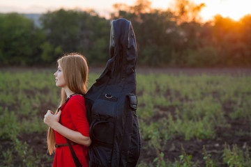 Woman traveller with cello outdoors © Andrey Milkin